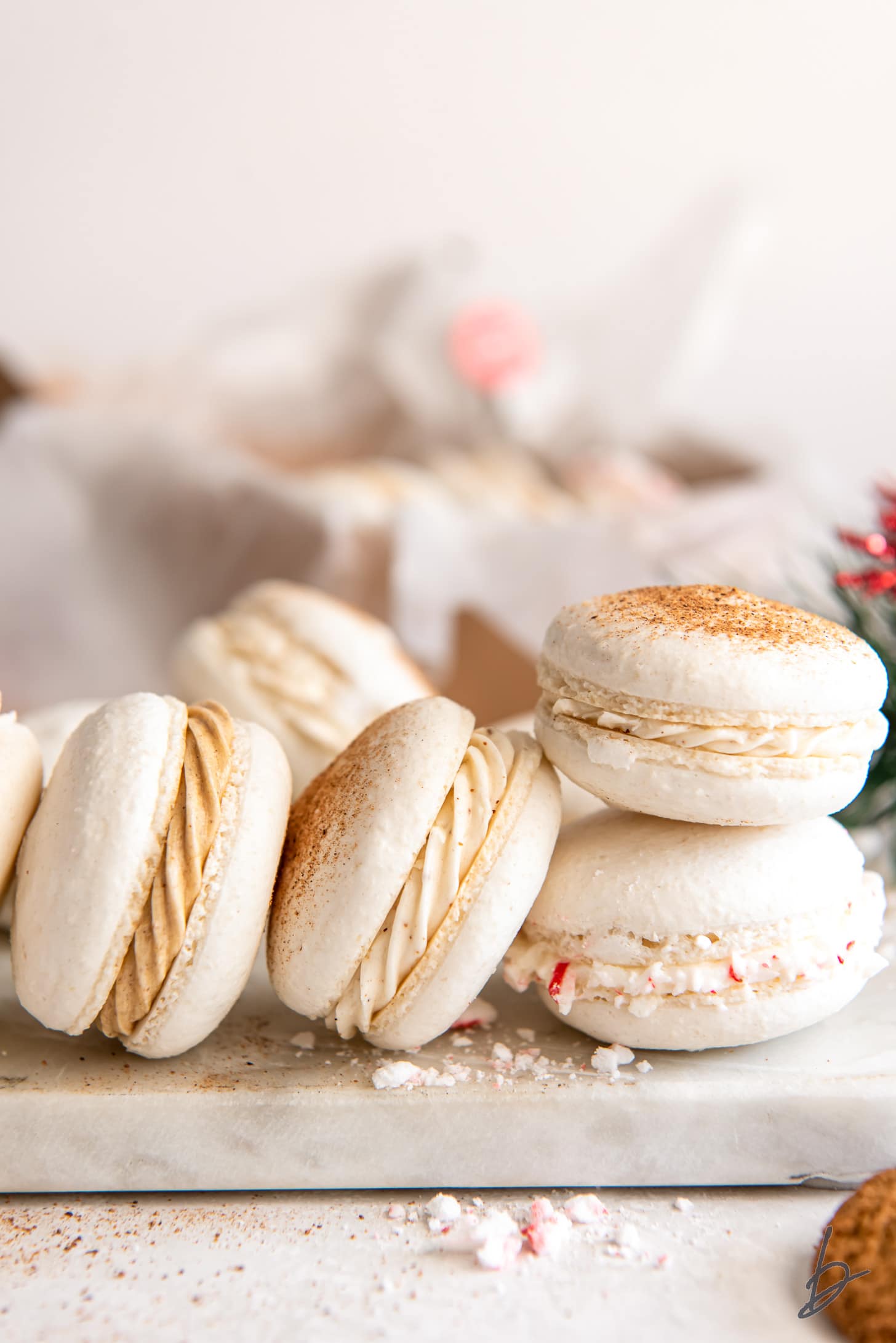 four christmas macarons stacked against each other showing different festive fillings inside.