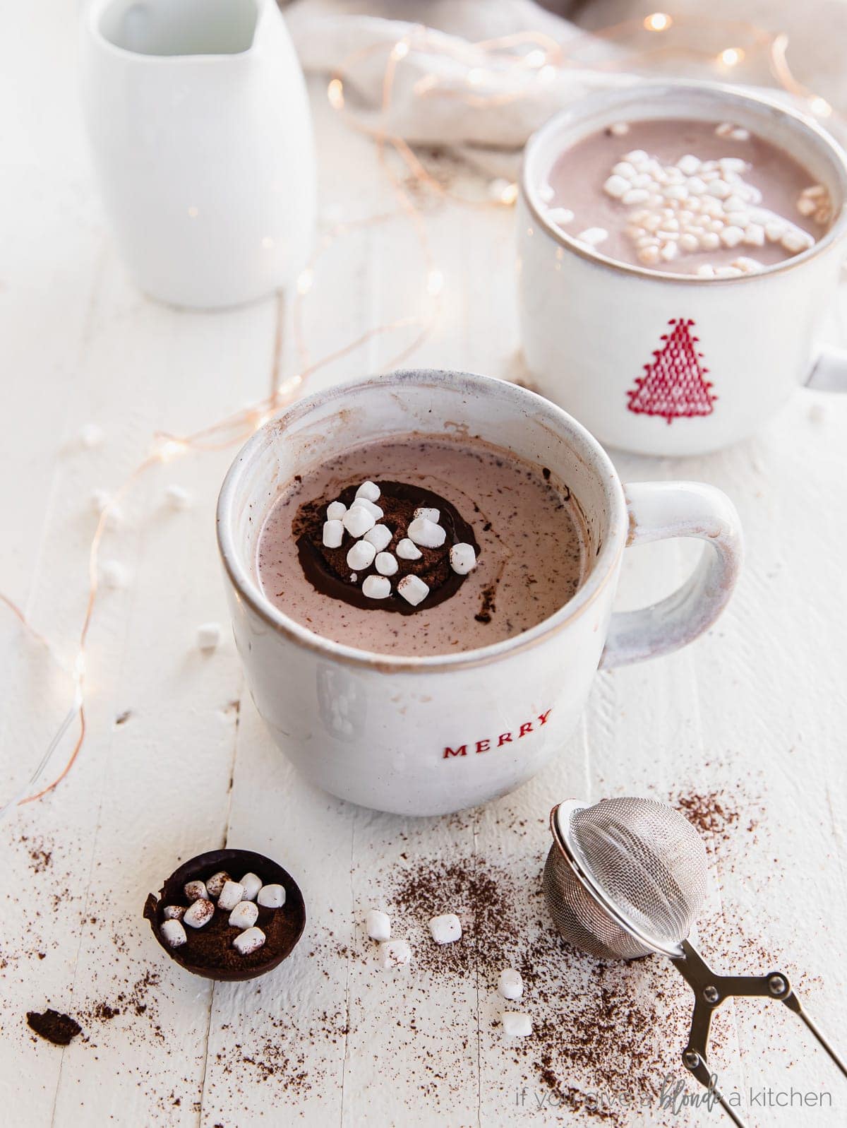 mug of hot chocolate with an open chocolate bomb with mini marshmallows in the mug