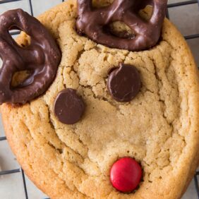 reindeer cookies with chocolate chip eyes, red candy nose and pretzel antlers