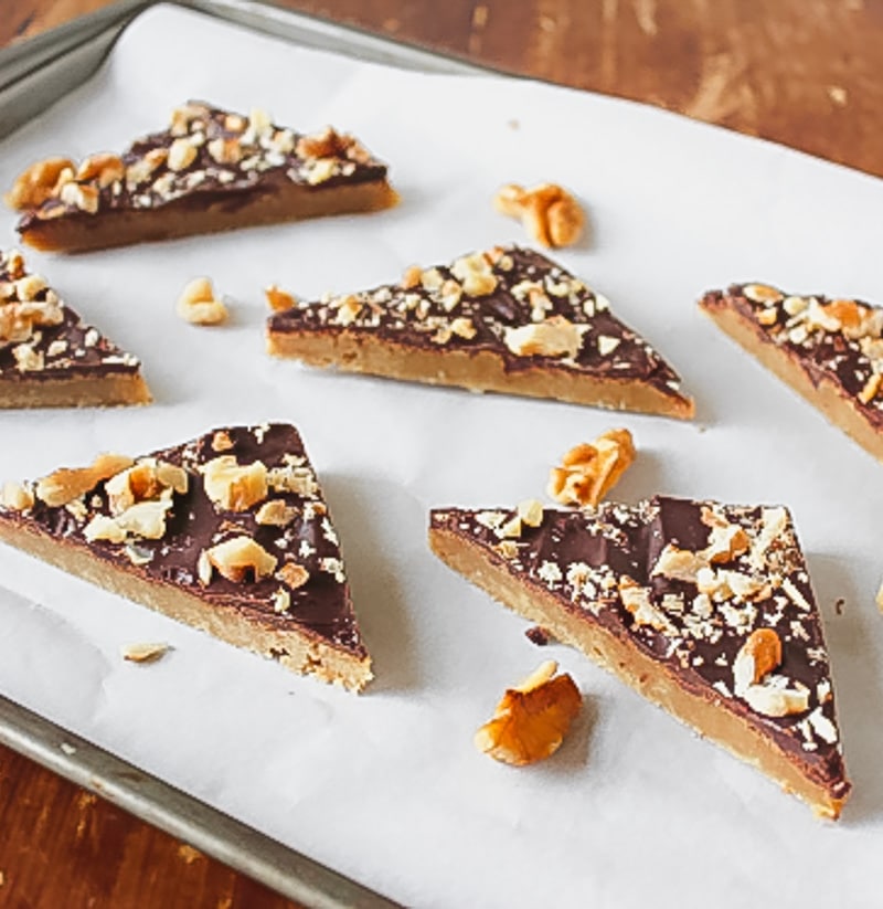 toffee bars cut into triangles spread apart on parchment lined baking sheet