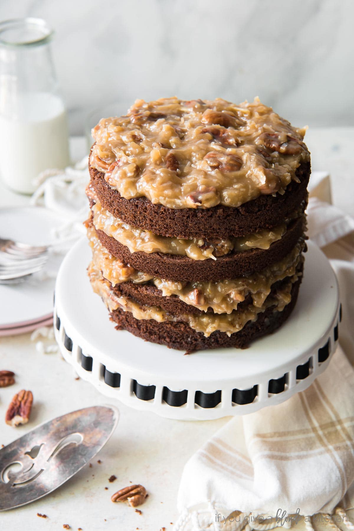 layered german chocolate cake on white cake stand