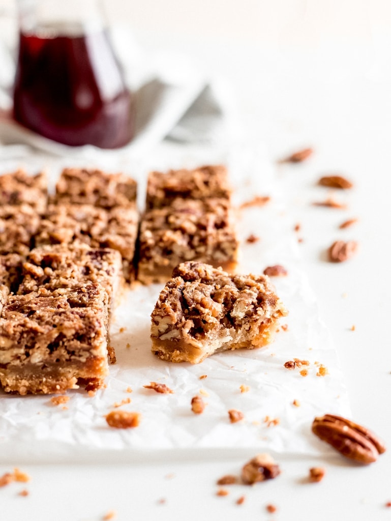 maple pecan bars with bite showing shortbread crust and chopped nuts
