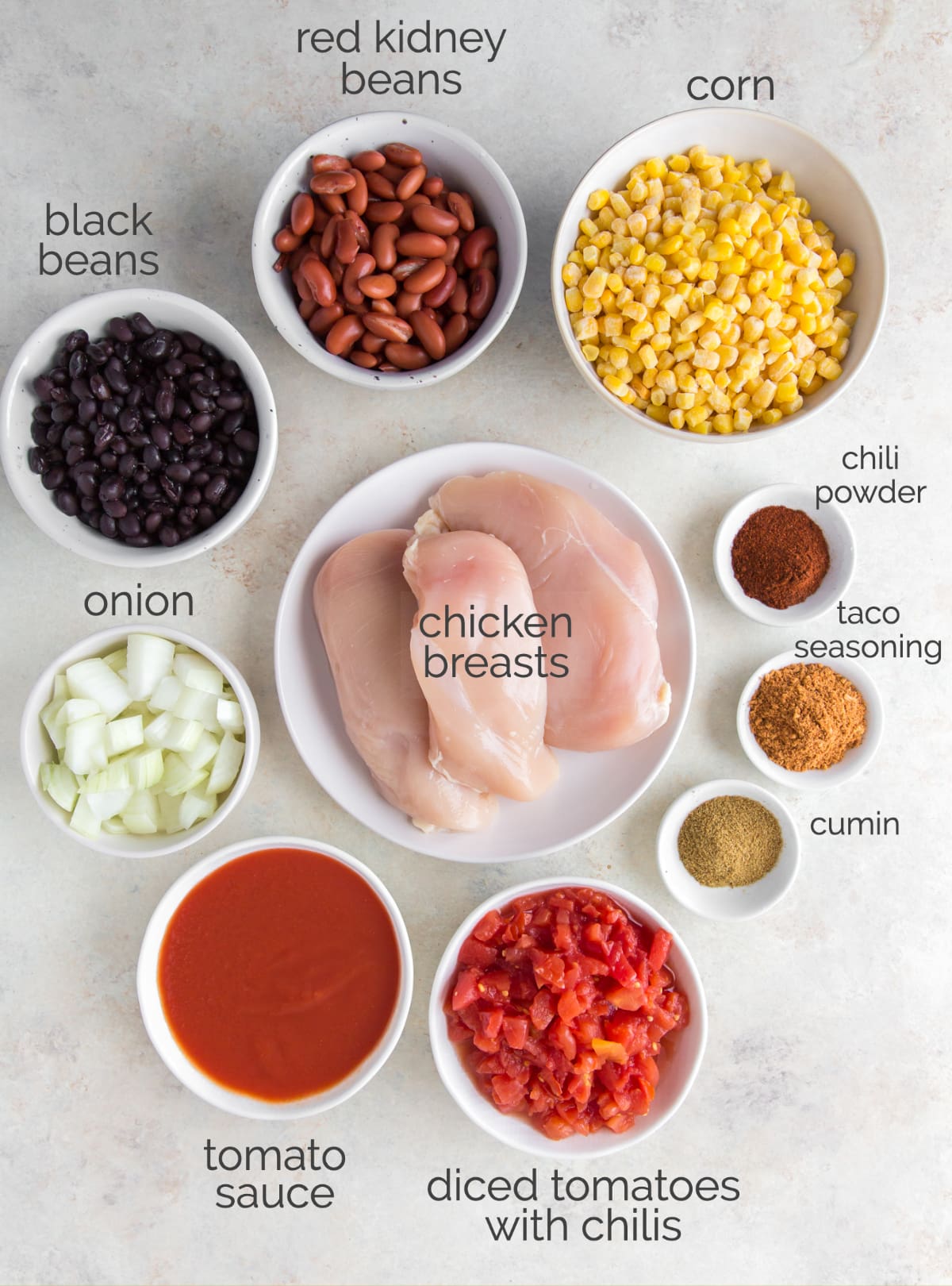 slow cooker chicken chili ingredients in bowls labeled with text