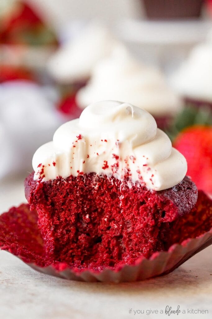 red velvet cupcake with cream cheese frosting and a bite taken