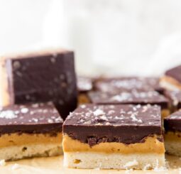 side of peanut butter chocolate bar showing layers of shortbread crust, peanut butter filling and chocolate topping