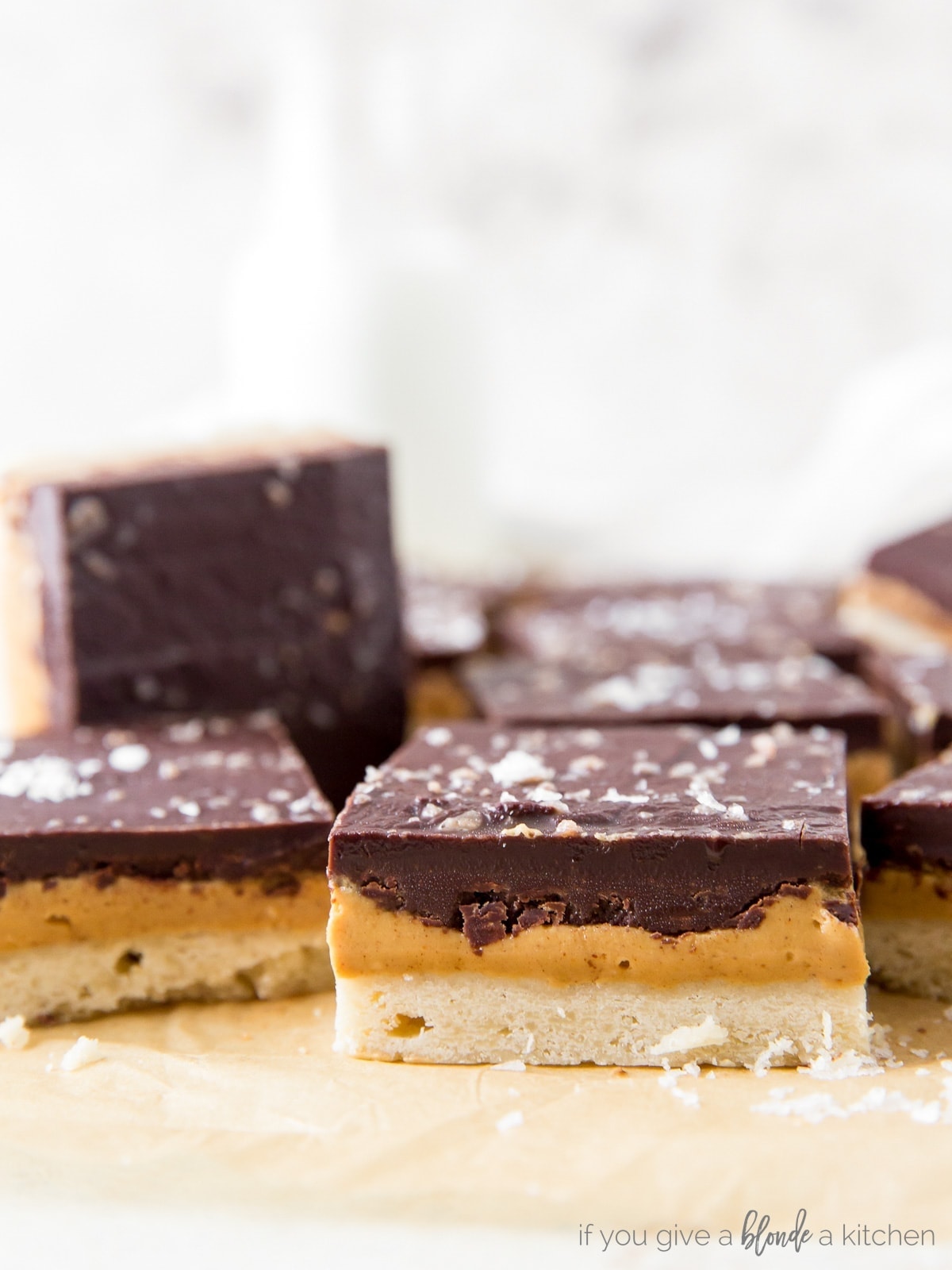 side of peanut butter chocolate bar showing layers of shortbread crust, peanut butter filling and chocolate topping