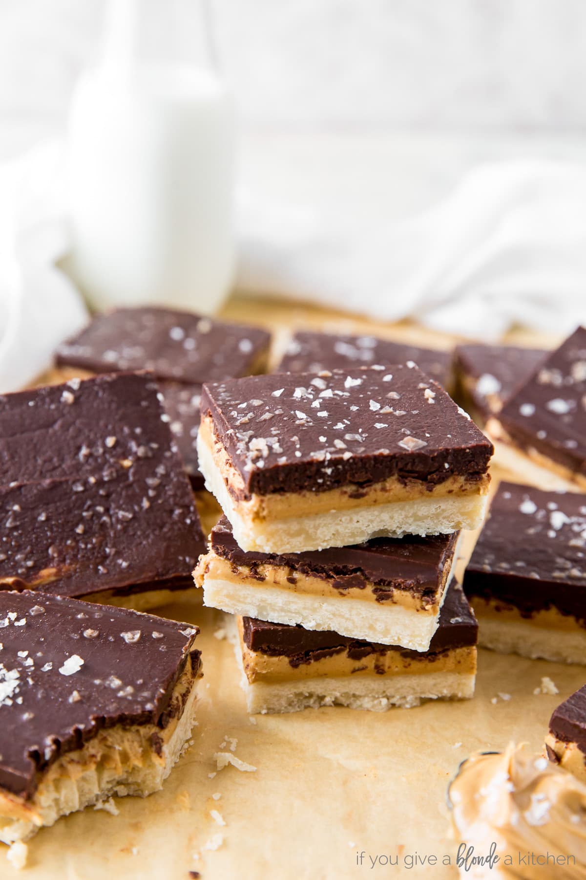 stack of three peanut butter chocolate bars surrounded by more bars on parchment paper