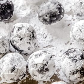 rum balls coated in confectioners' sugar on parchment paper