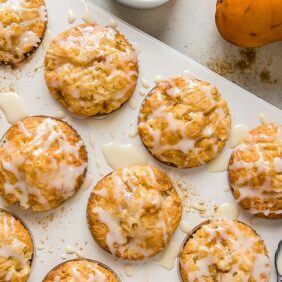 ginger pear muffins with glaze in a muffin tin