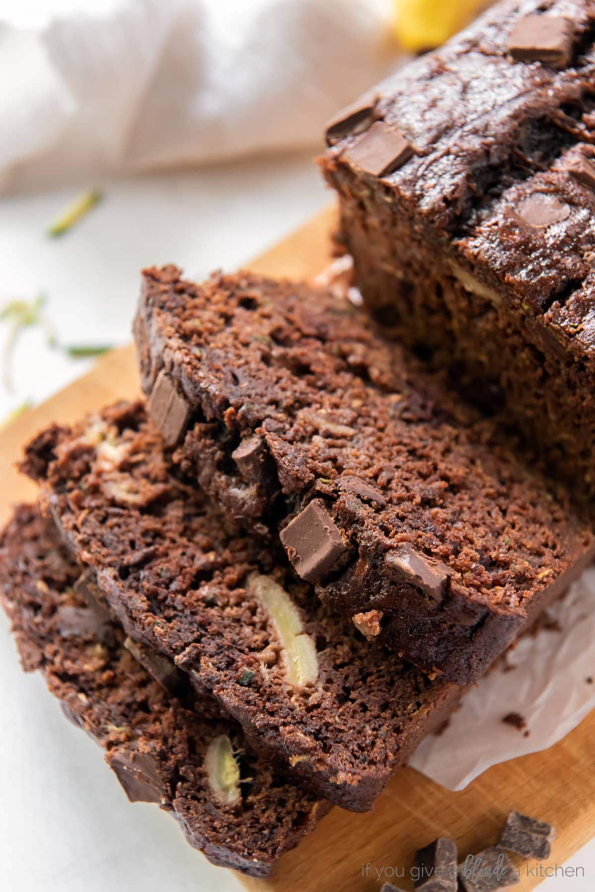 three slices of chocolate zucchini banana bread cut off loaf on cutting board