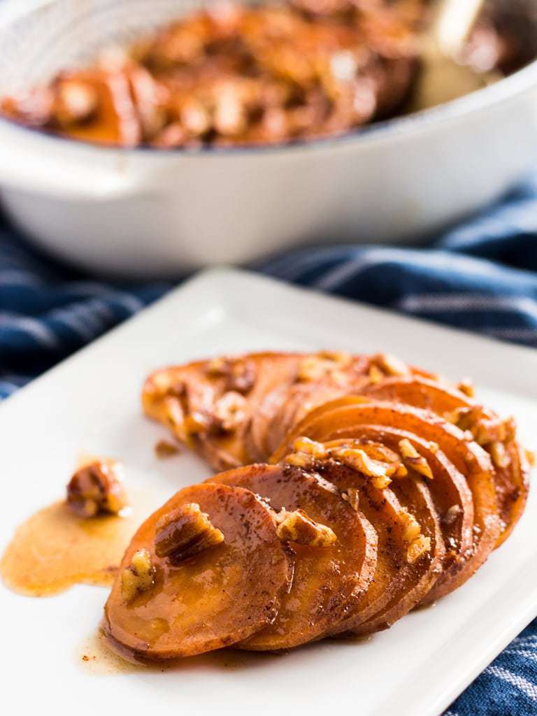 serving of sweet potato slices on plate with maple glaze and pecans.