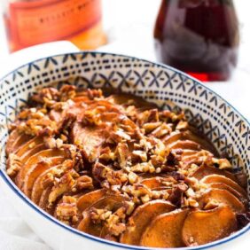 bourbon maple sweet potato casserole with pecans on top in a dish.