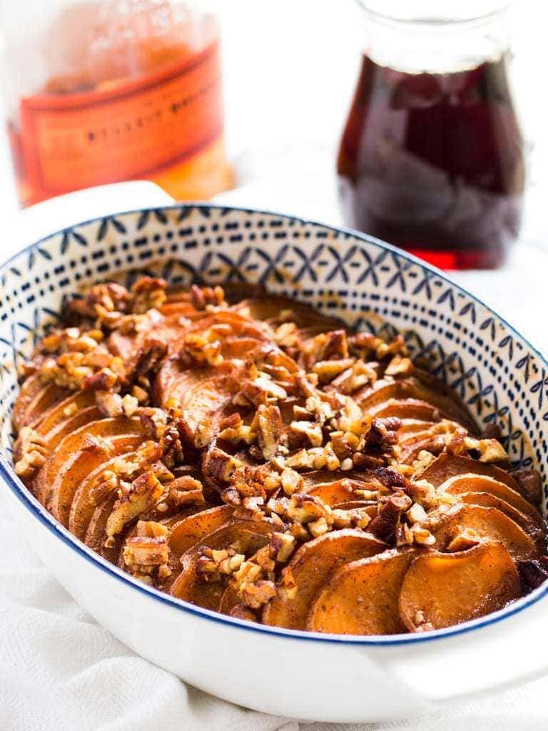 bourbon maple sweet potato casserole with pecans on top in a dish.