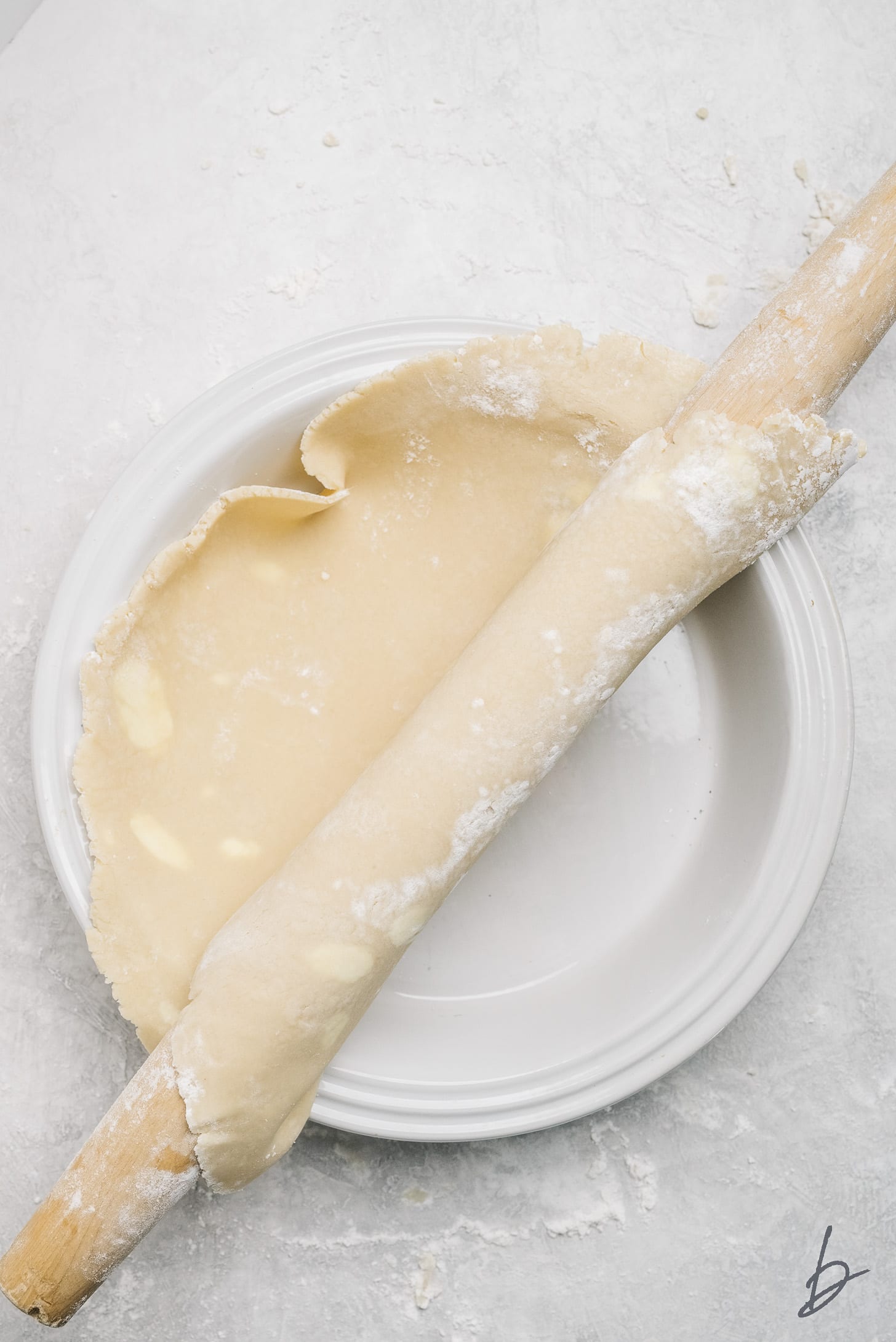 pie crust on rolling pin transferred to pie plate.