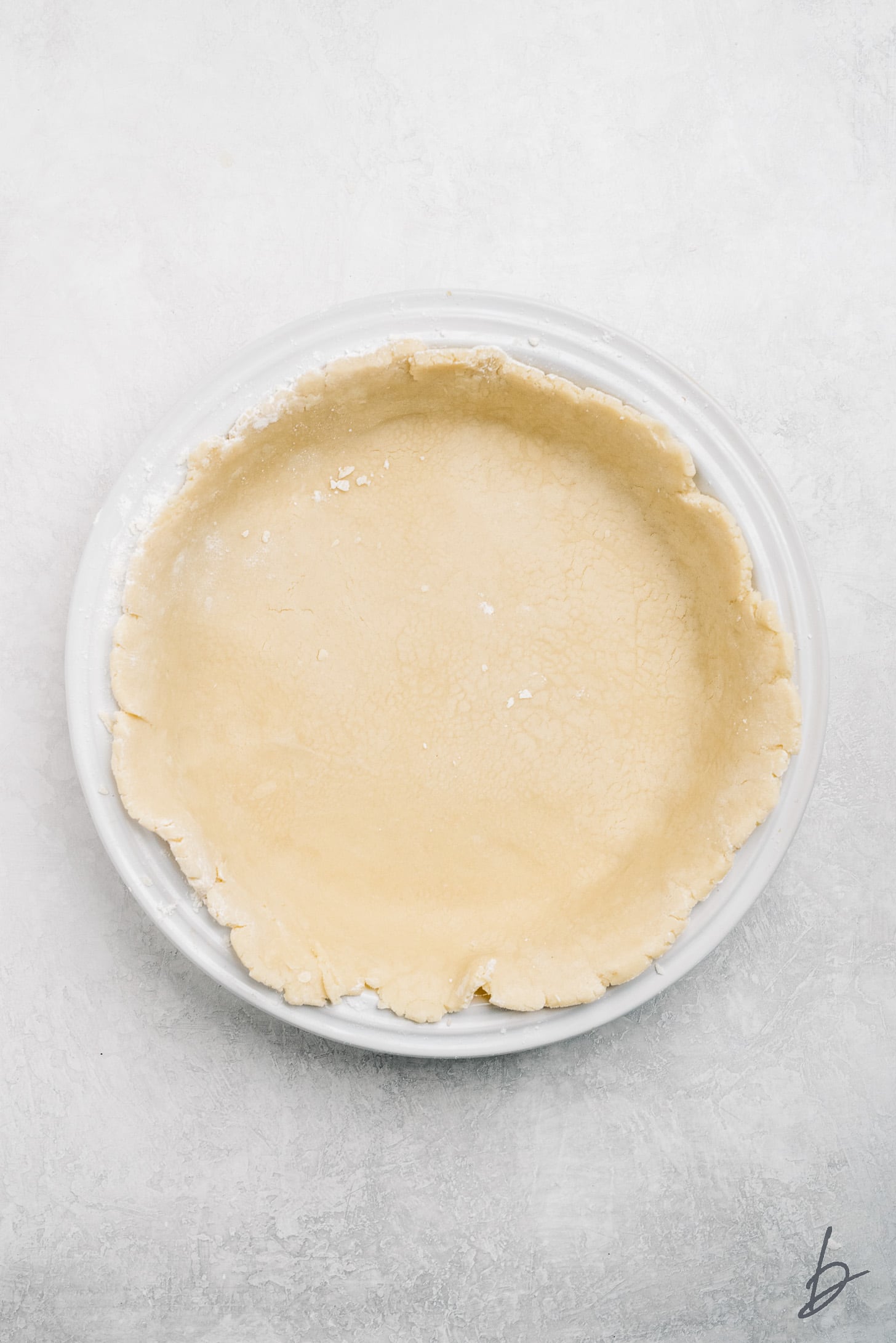 homemade pie crust in a white pie dish.