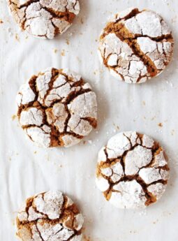 gingerbread crinkle cookies coated in powdered sugar on parchment paper