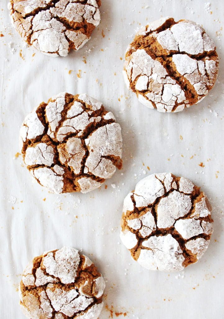 gingerbread crinkle cookies coated in powdered sugar on parchment paper