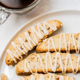 three almond biscotti on top half of a round white plate