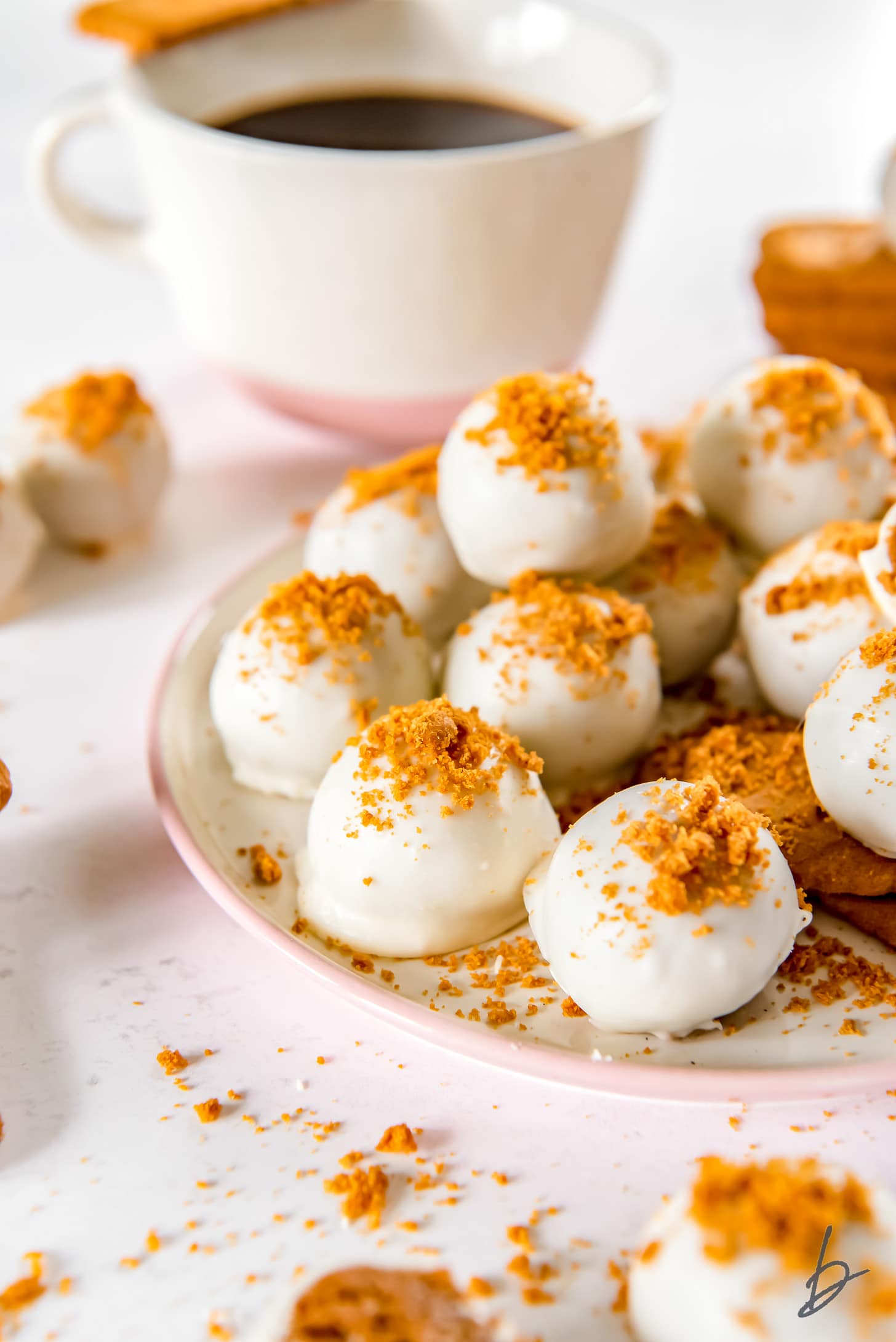 plate of white chocolate covered biscoff truffles topped with crushed biscoff cookie crumbs