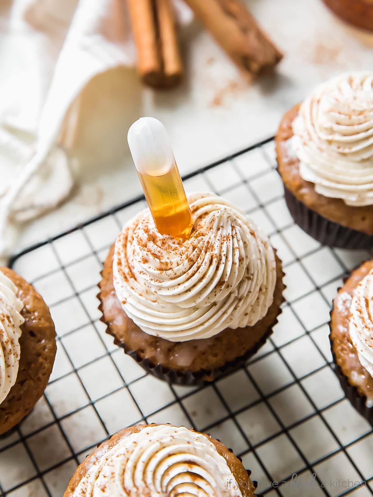buttered rum cupcake with squeeze shot tube filled with rum inserted in cupcake