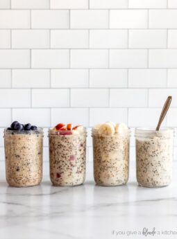 four jars of overnight oats on marble surface