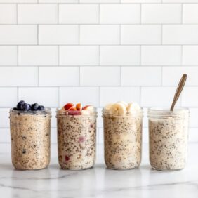 four jars of overnight oats on marble surface
