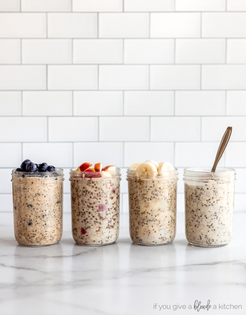 four jars of overnight oats on marble surface