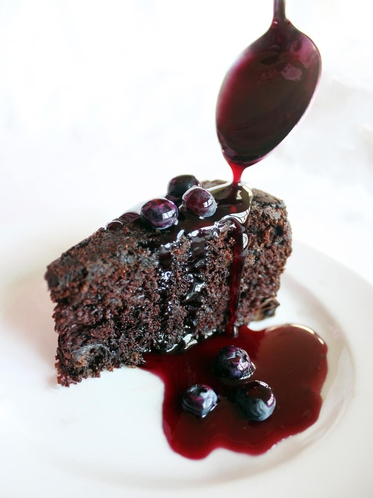 The delicious chocolate cake is sweetened with blueberries in and on the cake. The blueberry sauce is not only delicious on the cake, but on ice cream too!| Recipe by @haleydwilliams