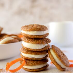 stack of four carrot cake whoopie pies with one whoopie pie leaning against stack