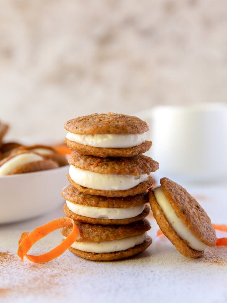 stack of four carrot cake whoopie pies with one whoopie pie leaning against stack
