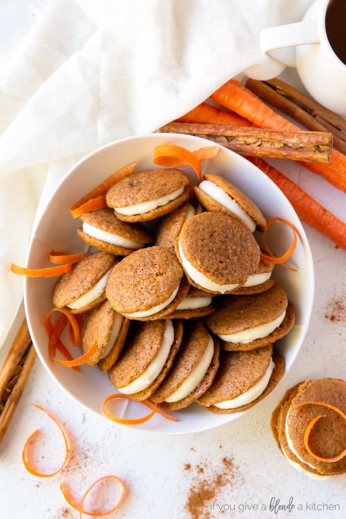 Mini carrot cake whoopie pies on a plate with blue striped towel