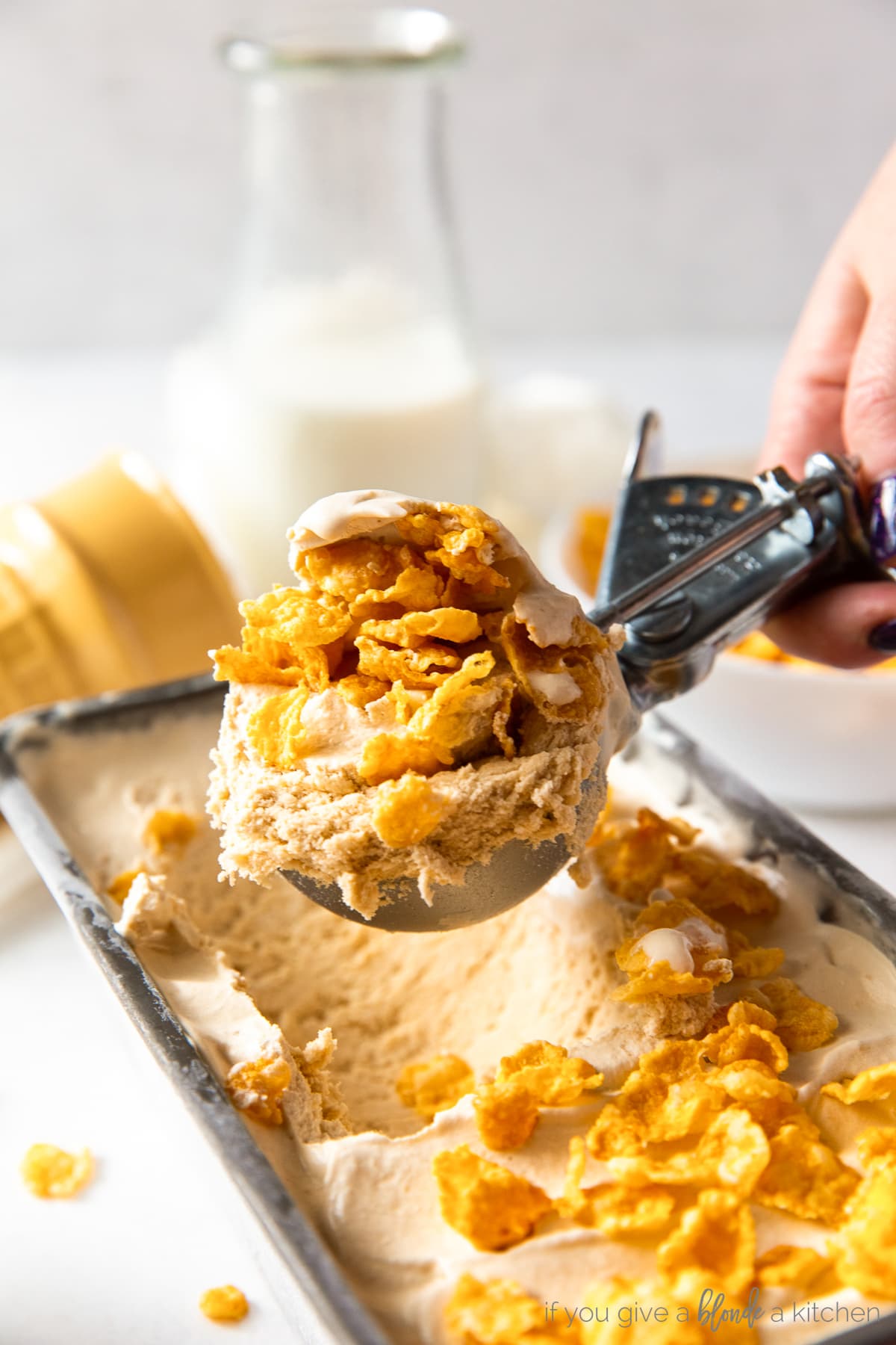 ice cream scooper with cereal milk ice cream and corn flakes