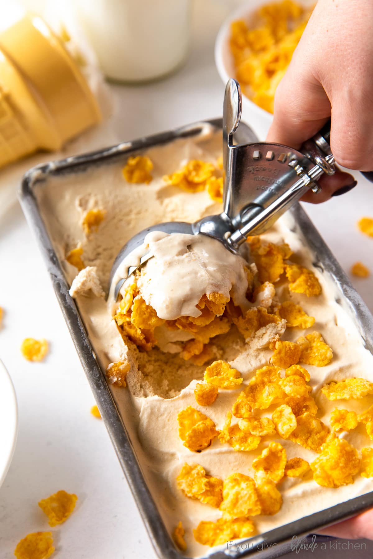 ice cream scoop scooping cereal milk ice cream with corn flakes out of a loaf pan