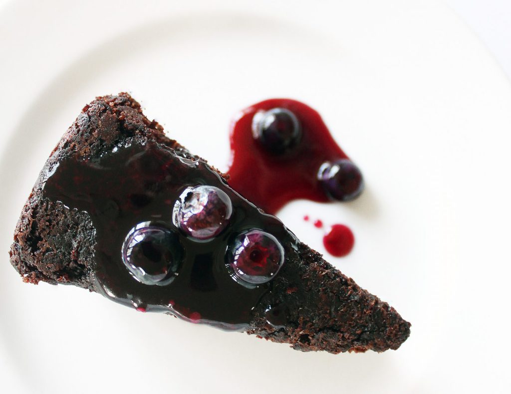 The delicious chocolate cake is sweetened with blueberries in and on the cake. The blueberry sauce is not only delicious on the cake, but on ice cream too!| Recipe by @haleydwilliams