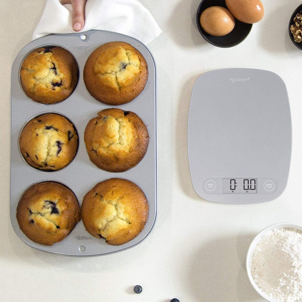 digital kitchen scale next to muffin win with muffins