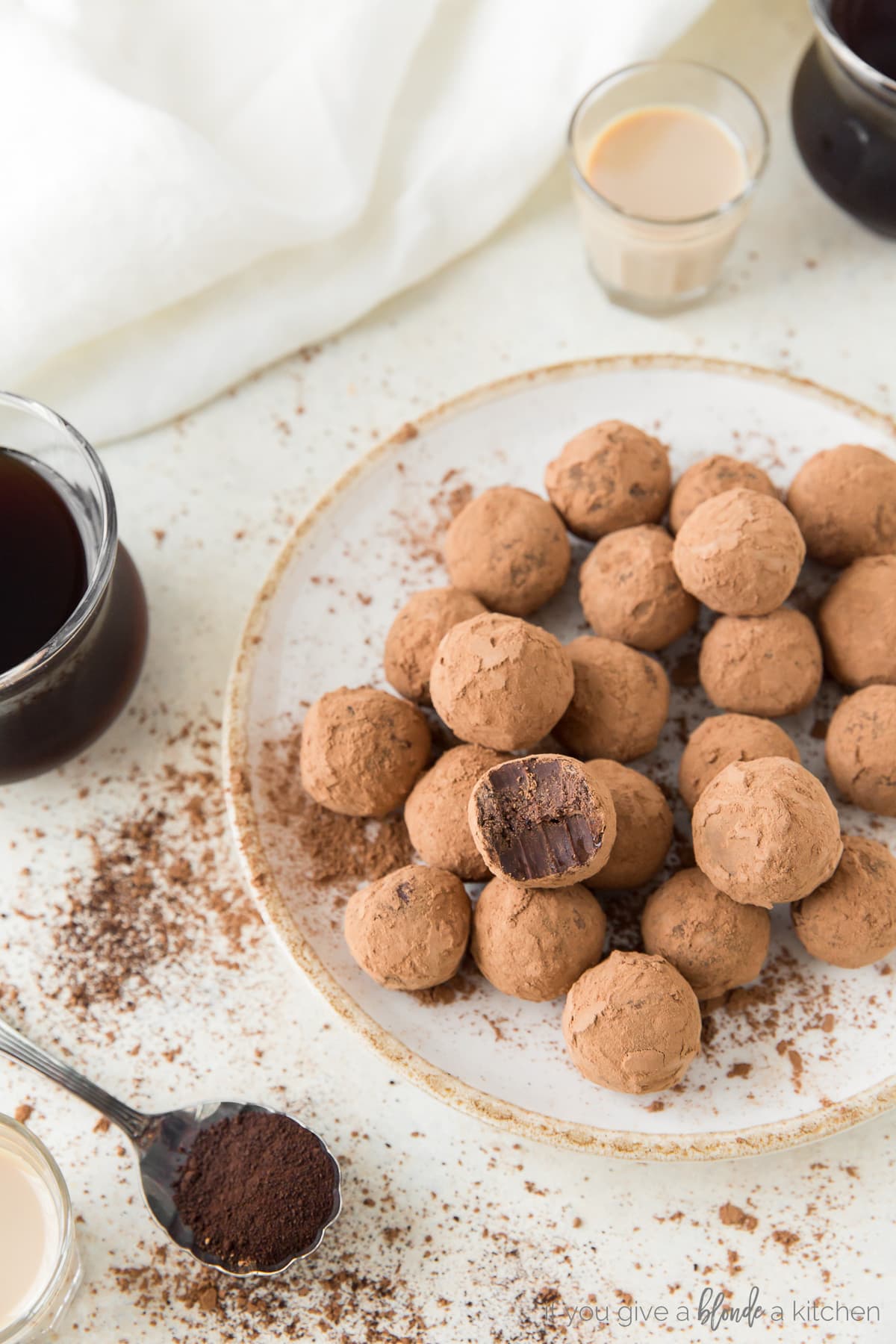 plate of cocoa covered espresso truffles; spoon of espresso and glass of coffee next to plate