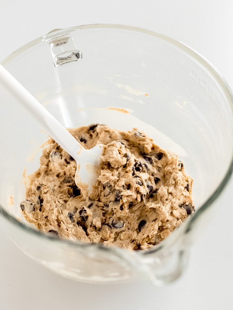 glass bowl of banana oatmeal cookie dough with rubber spatula