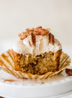 hummingbird cupcake with a bite sitting on paper cupcake liner