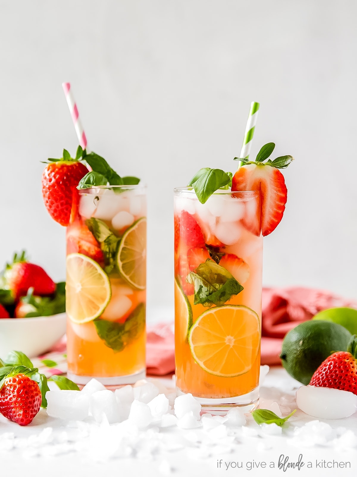 two tall glasses of strawberry mojito with basil and lime