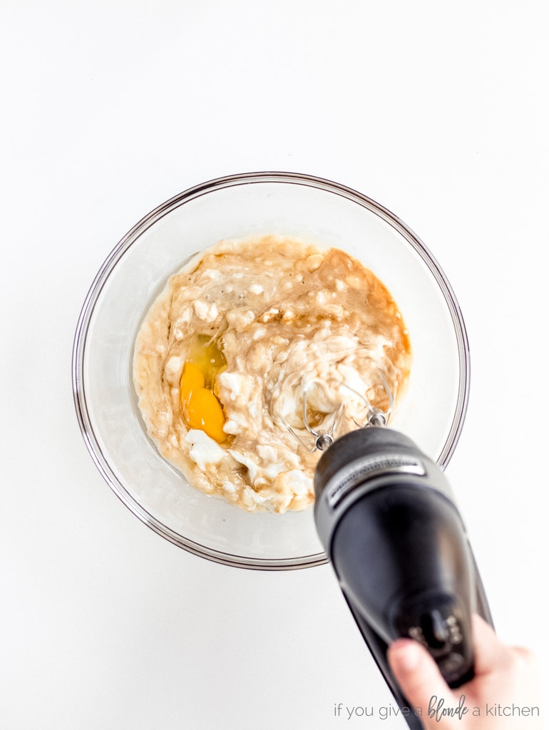 hand mixer combining ingredients in glass bowl