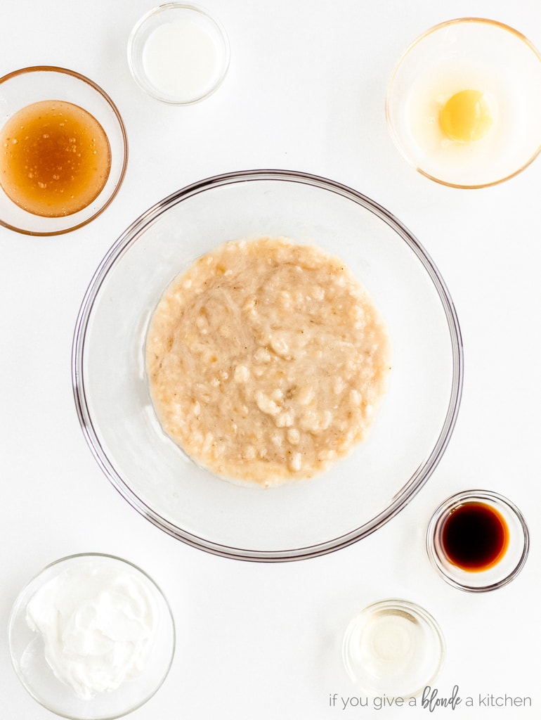 mashed bananas in large glass bowl, small glass bowls honey, egg, vanilla, yogurt