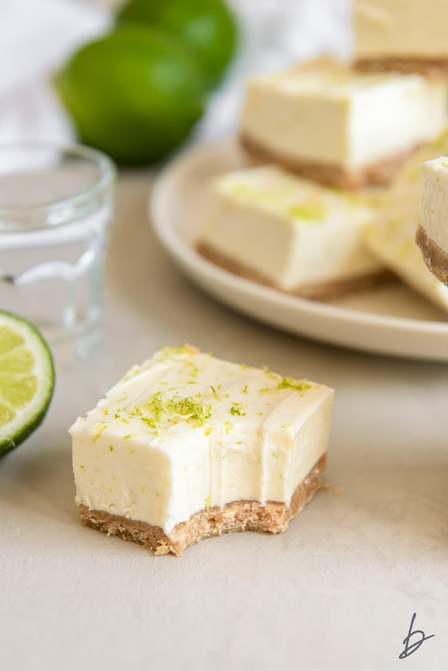 No bake margarita cheesecake bar with a bite and lime zest on top