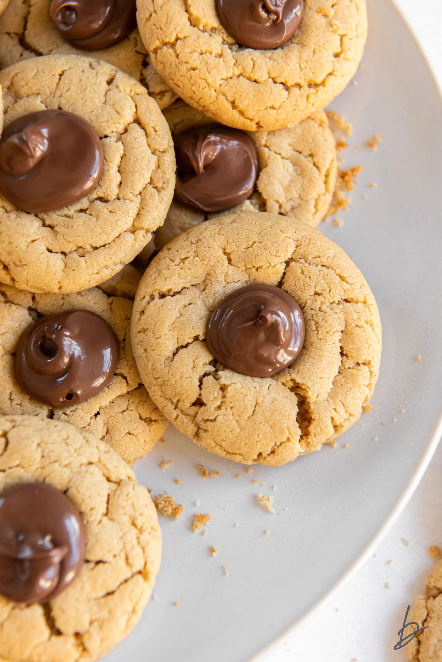 plate of peanut butter nutella cookies with nutella in thumbprint center.