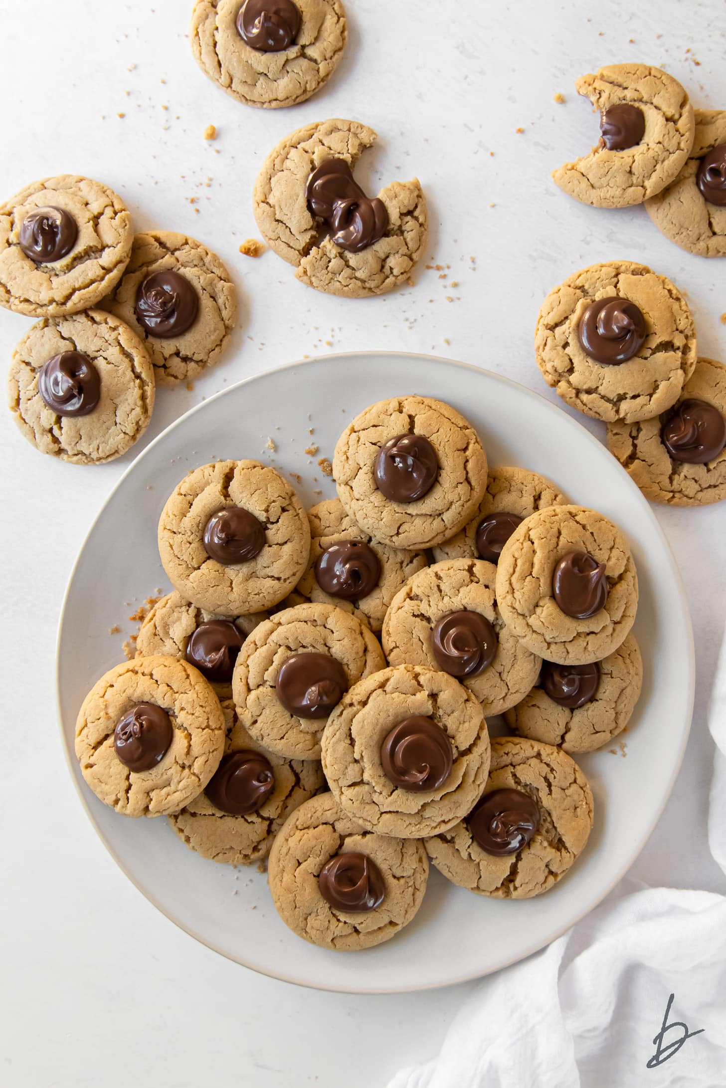 peanut butter nutella cookies on plate next to a few more cookies with nutella centers.