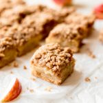 easy apple crisp bars square on parchment paper with apple slice