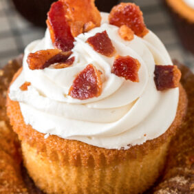 bacon bits on top of maple bourbon frosting on a maple bourbon cupcake