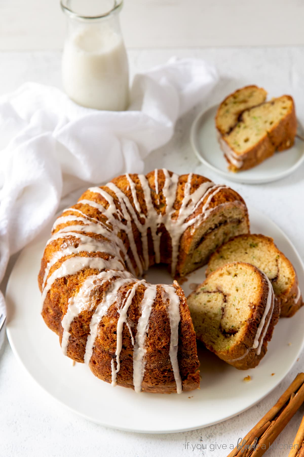 Cinnamon swirl zucchini bundt cake with cinnamon icing on top sitting on wire cooling rack