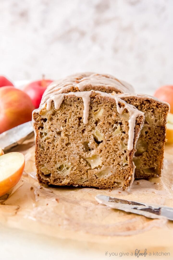 slice of apple cider bread with chunks of apples and glaze dripping down