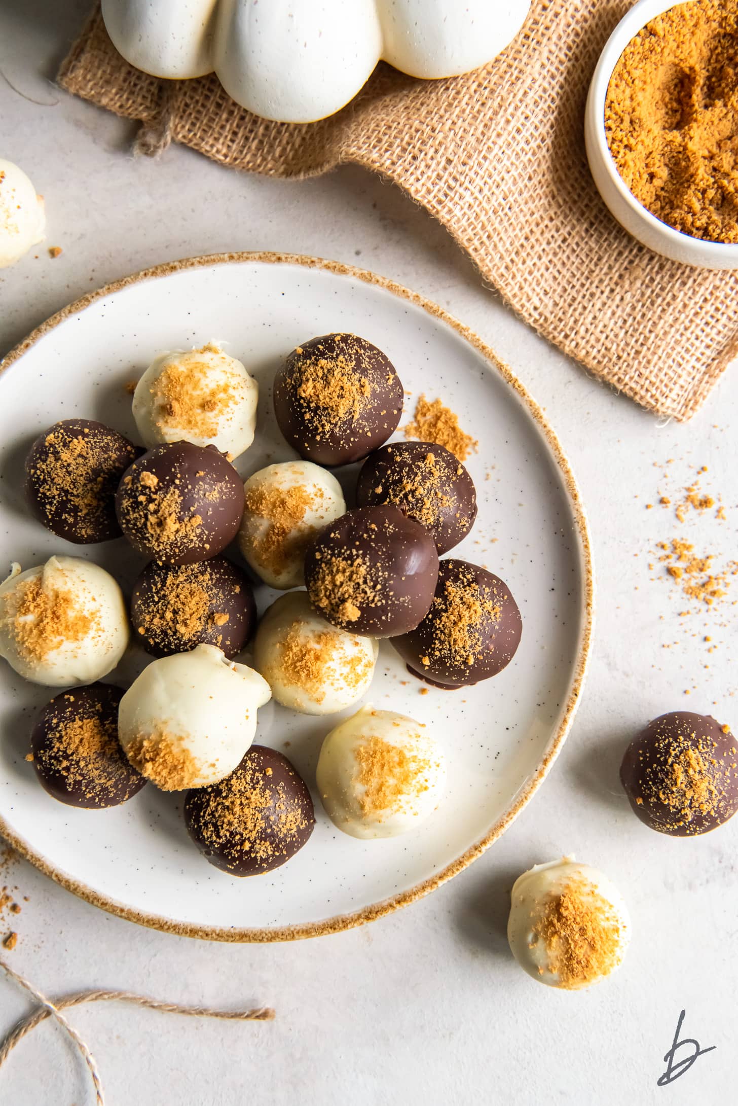 white chocolate and dark chocolate pumpkin pie truffles on a plate.