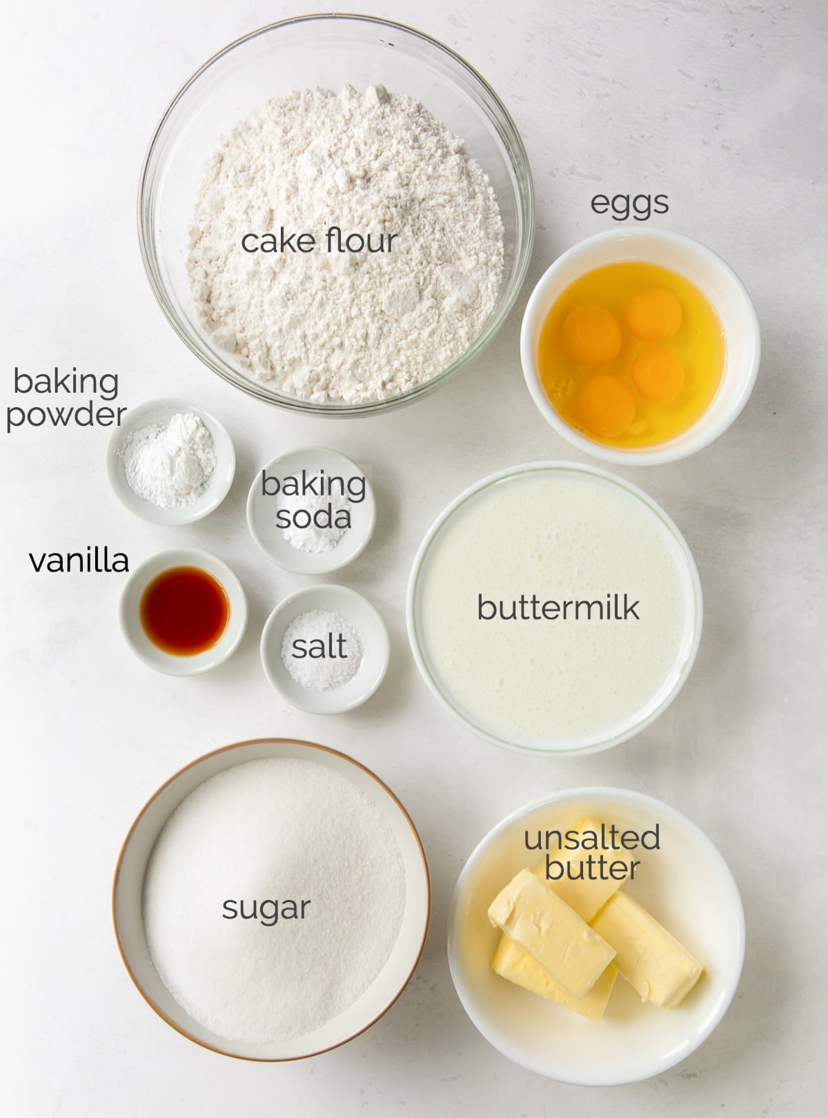 vanilla layer cake ingredients in bowls labeled with text